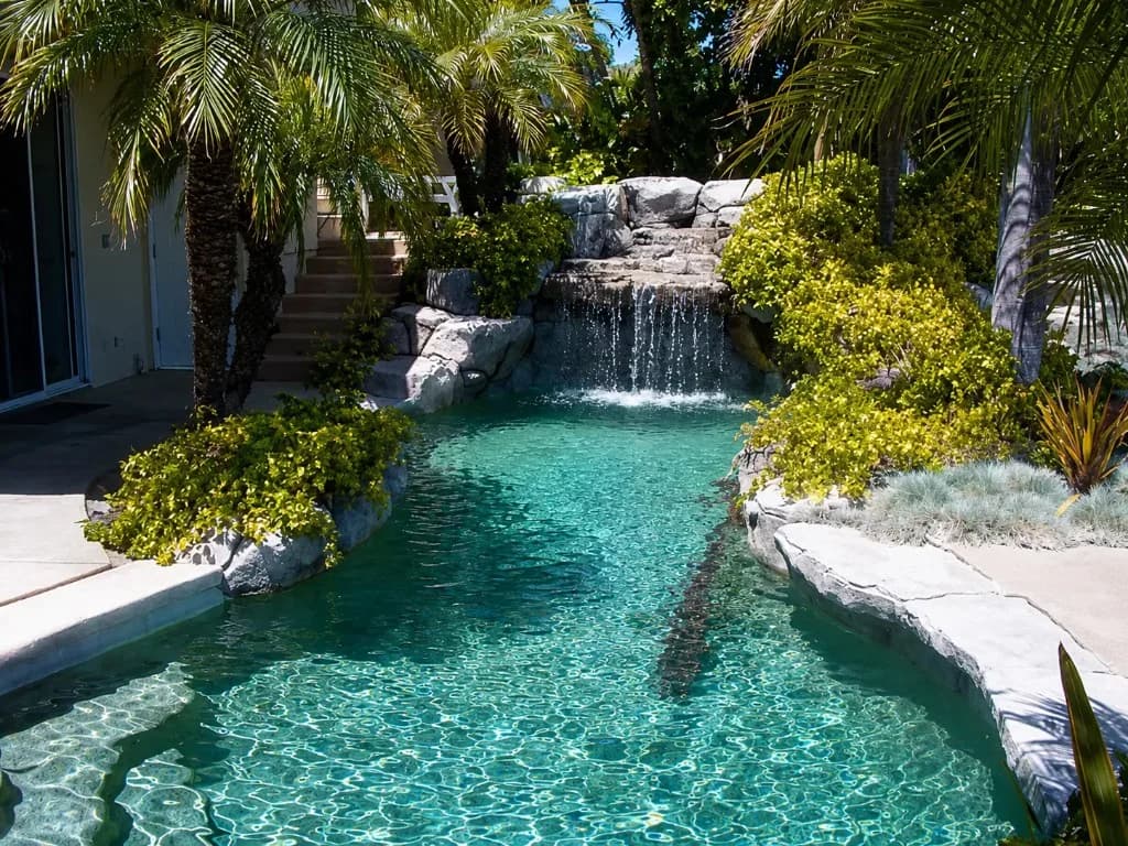 Past Auld Castle real estate sale — backyard pool with rock waterfall and tropical landscaping